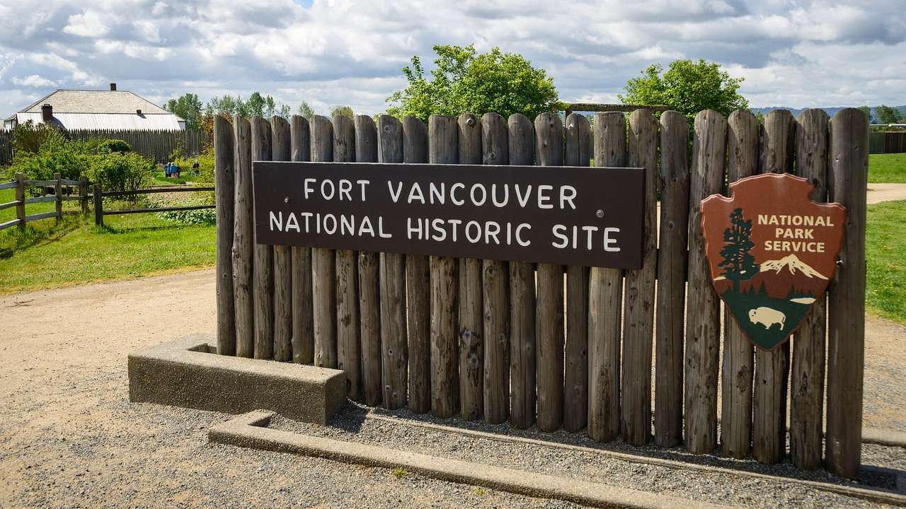 A fence with a sign that says "Fort Vancouver National Historic Site" next to a path