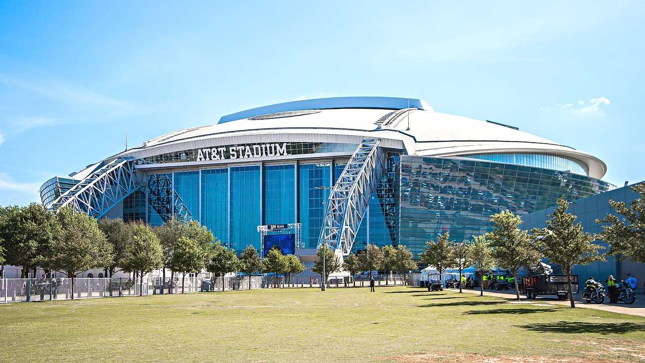 A football-shaped stadium with a glass front and a sign that says "AT&T Stadium"