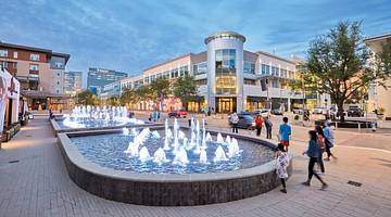 A square in a shopping center with a fountain and buildings around it