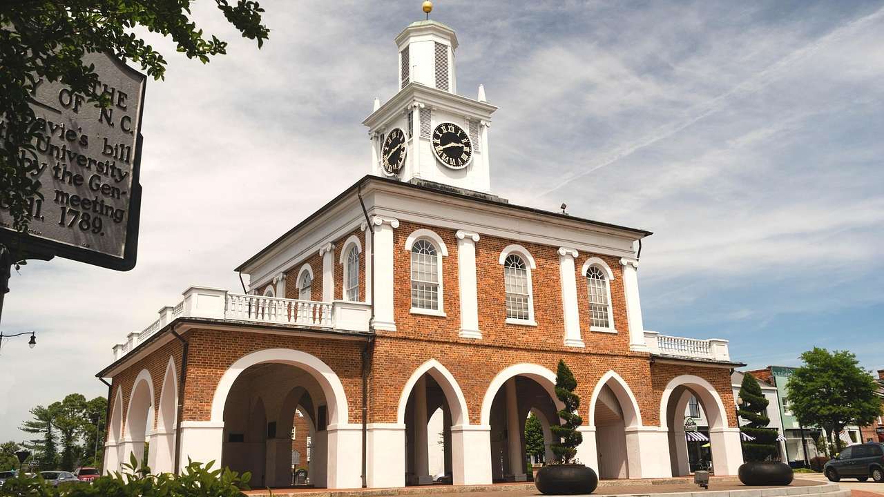 A red brick building with arches and a clock tower on top of it