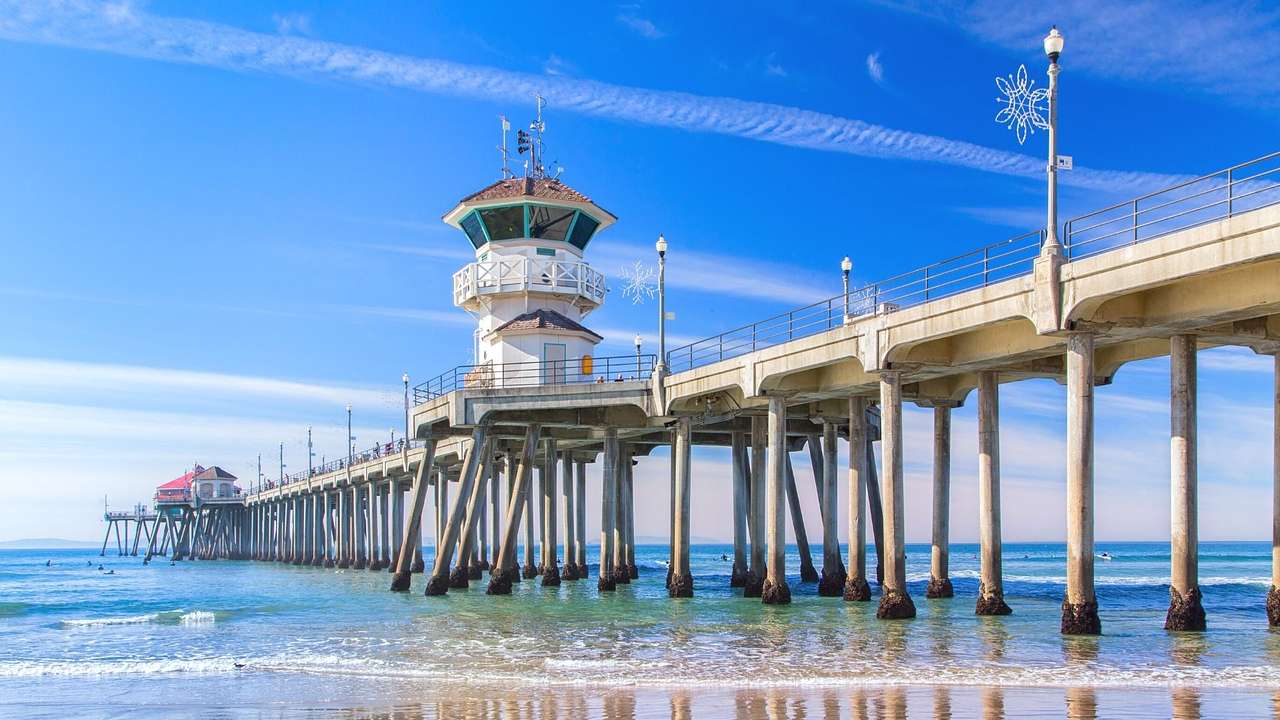 A pier stretching out into the ocean with a small tower structure on it