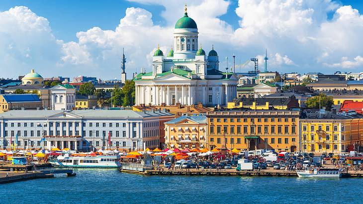 A white cathedral with turquoise domed roofs, in an old town, along water A white cathedral with turquoise domed roofs, in an old town, along water