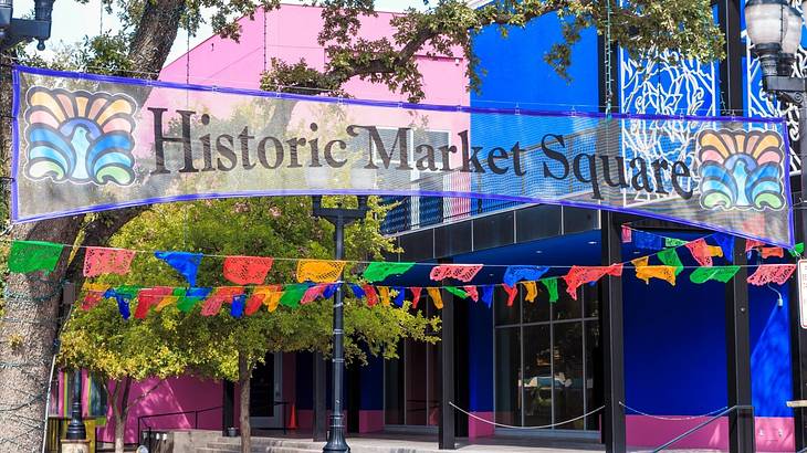 A colorful street with flags and a sign that says "Historic Market Square"