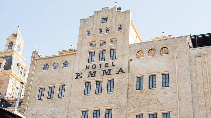 A castle-like stone building with a black sign that says "Hotel Emma"