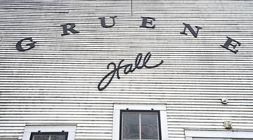 A paneled building with a sign that says "Gruene Hall"