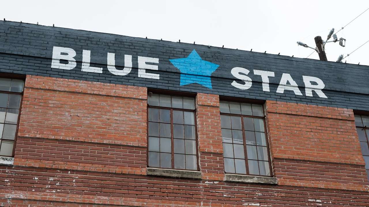 A brick building with a painted sign that says "Blue Star" and a blue star symbol