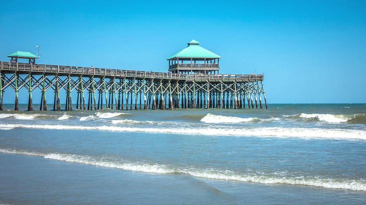 Ocean water with waves and a pier stretching out