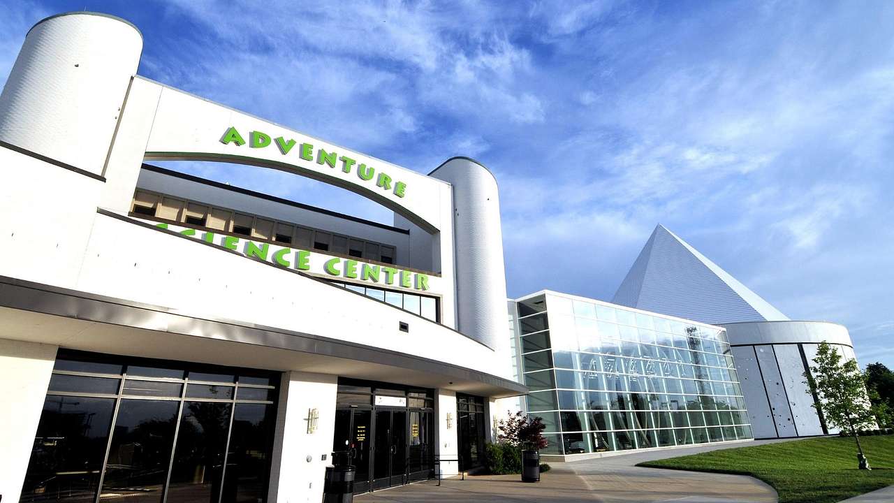 A white museum building with a green "Adventure Science Center" sign