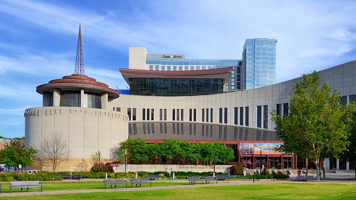 A museum with a rotunda building attached and grass and trees in front of it