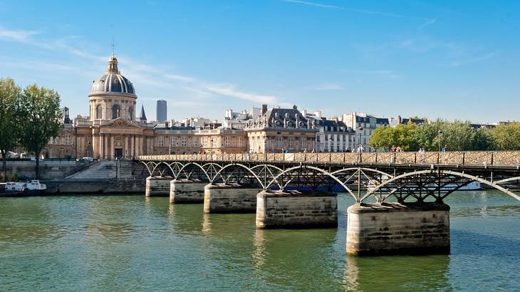 A bridge across a river with a building with a domed roof on one side of it