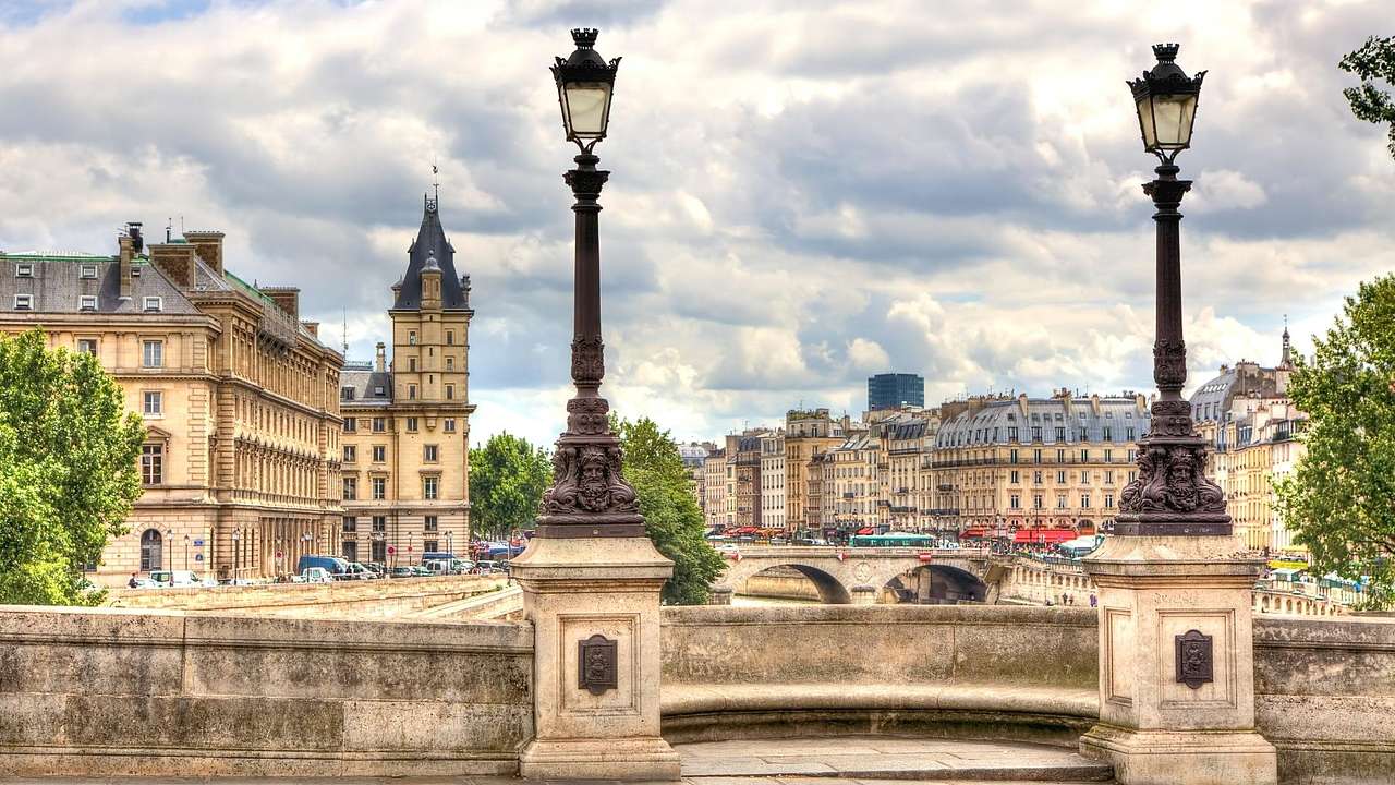 The view from a bridge of a river, another bridge, and French-style buildings