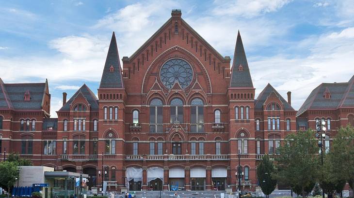 A red brick building with towers and a round stained glass window