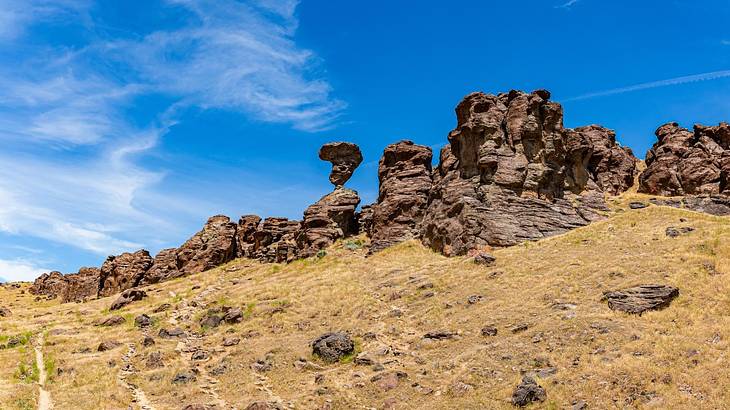 A hill with rock formations on it under a blue sky