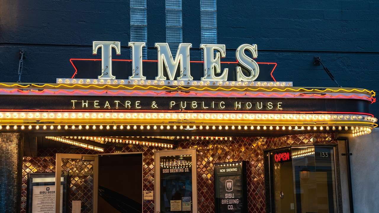 An entrance to a bar with illuminated signs that say "Times Theatre & Public House"