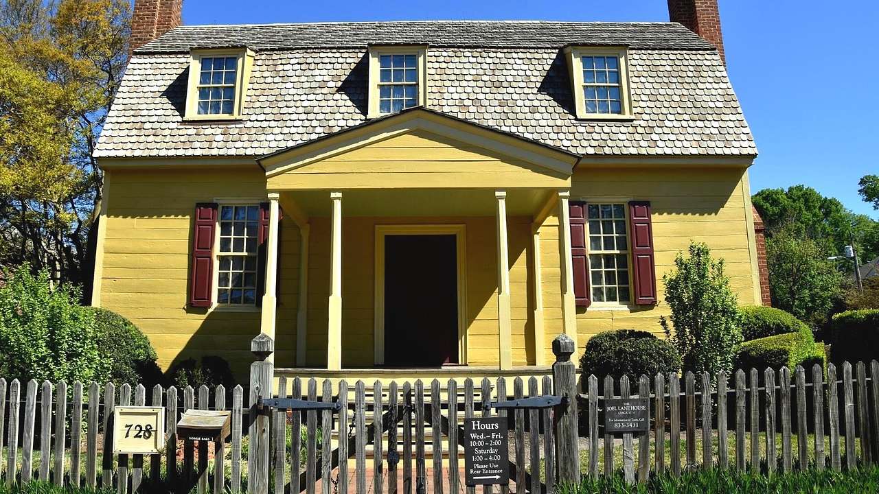 An old-fashioned yellow house with a wooden gate