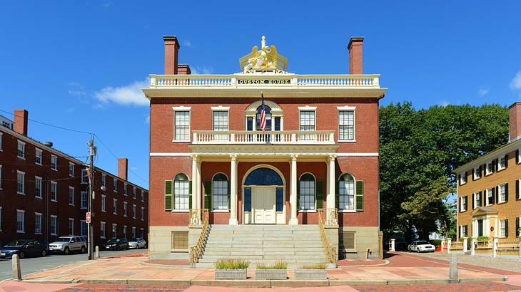 A regal red brick house with other buildings and a street around it