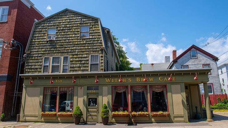 A wood and stone building with a "Witch's Brew Cafe" sign