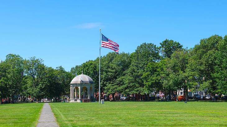 A green with a bandstand and US flag on it and a path down the middle