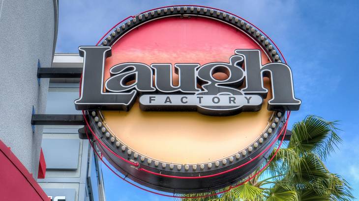 A round sign on a building that says "Laugh Factory" A round sign on a building that says "Laugh Factory"
