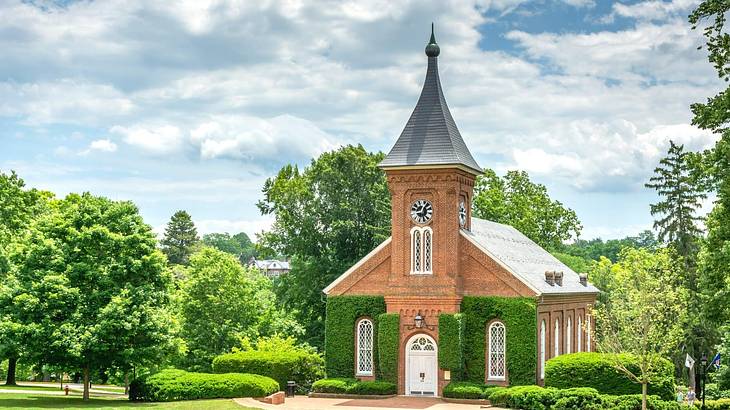 A small brick chapel with greenery surrounding it