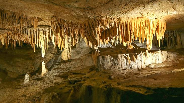 A yellow-colored cave system with hanging rock formations