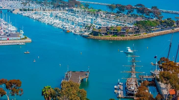 An aerial view of a marina with blue water, piers, and docked boats