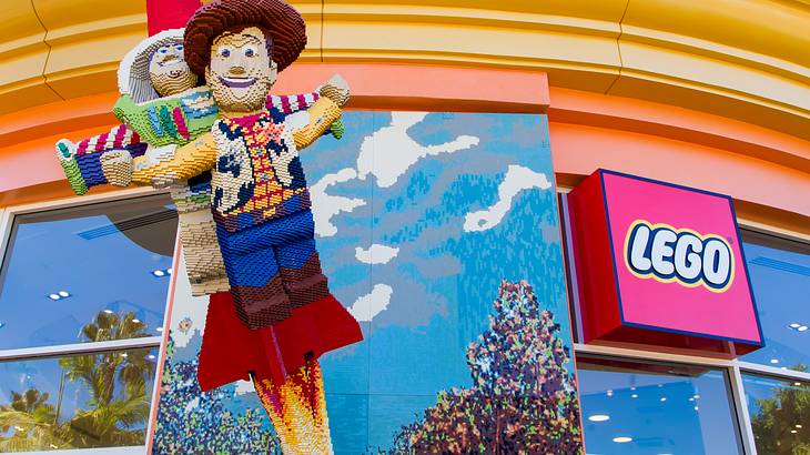 Lego figures from Toy Story on the front of a store with a Lego sign