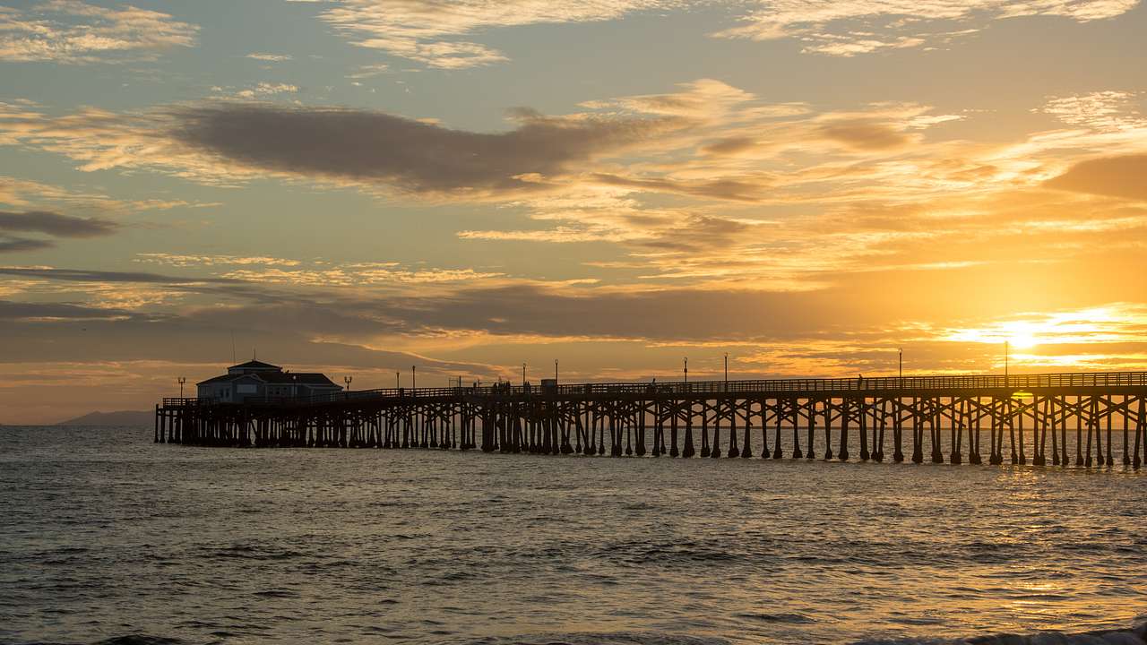 A pier stretching out into the ocean at sunset