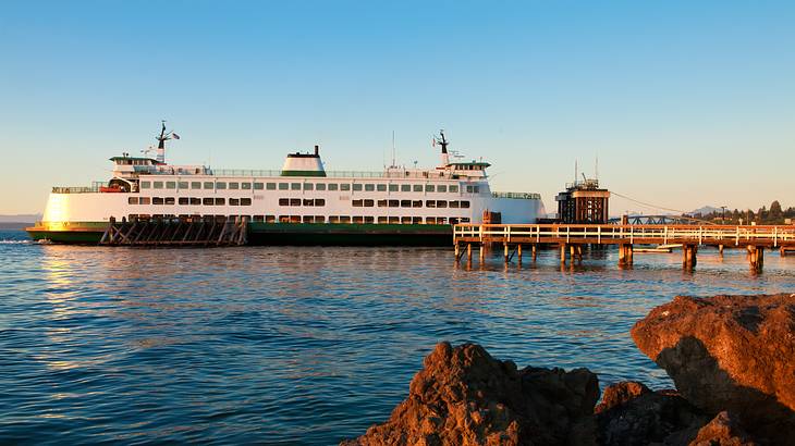 A ferry in the water with a pier next to it at dusk