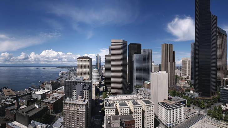 Tall buildings under a dark sky with the ocean to the side