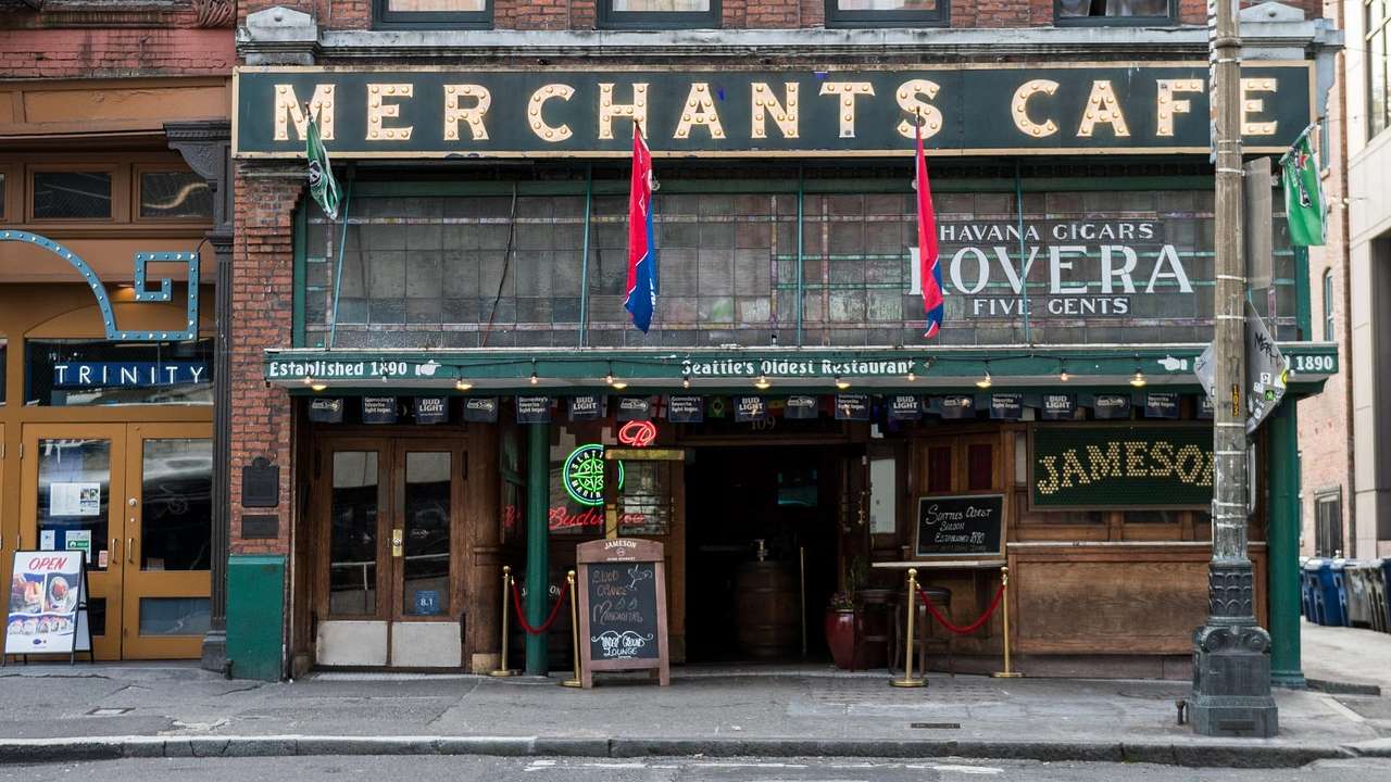 An old-fashioned bar with a "Merchants Cafe" sign on it