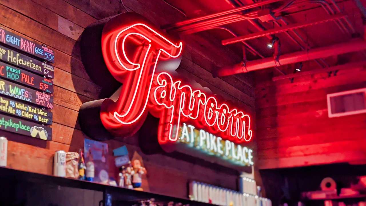 A red neon sign that says "Taproom" on the wall of a bar