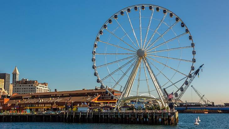 A Ferris wheel on a pier with water around it