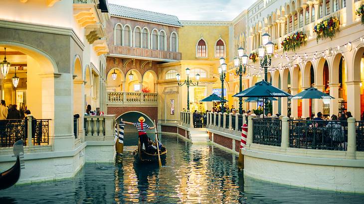 A gondola on a waterway surrounded by Italian-style buildings