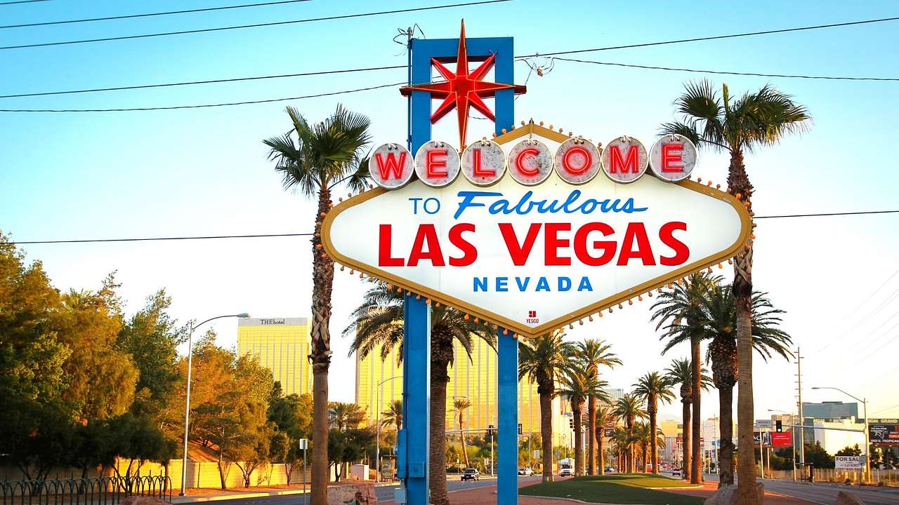 A "Welcome to Fabulous Las Vegas" sign with a road and palm trees behind it