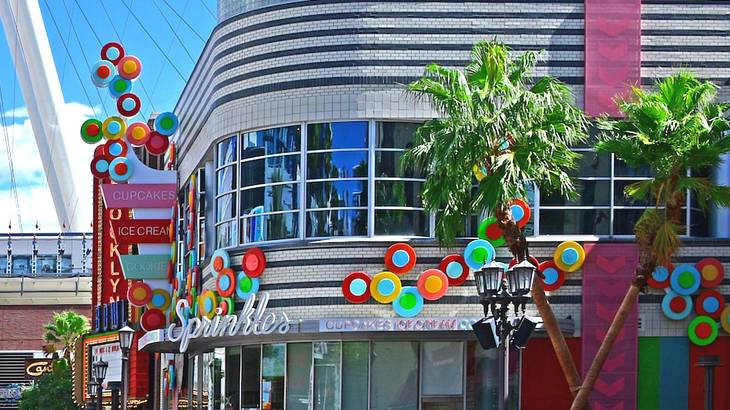 A building with colorful paint and a "Sprinkles" logo with palm trees in front