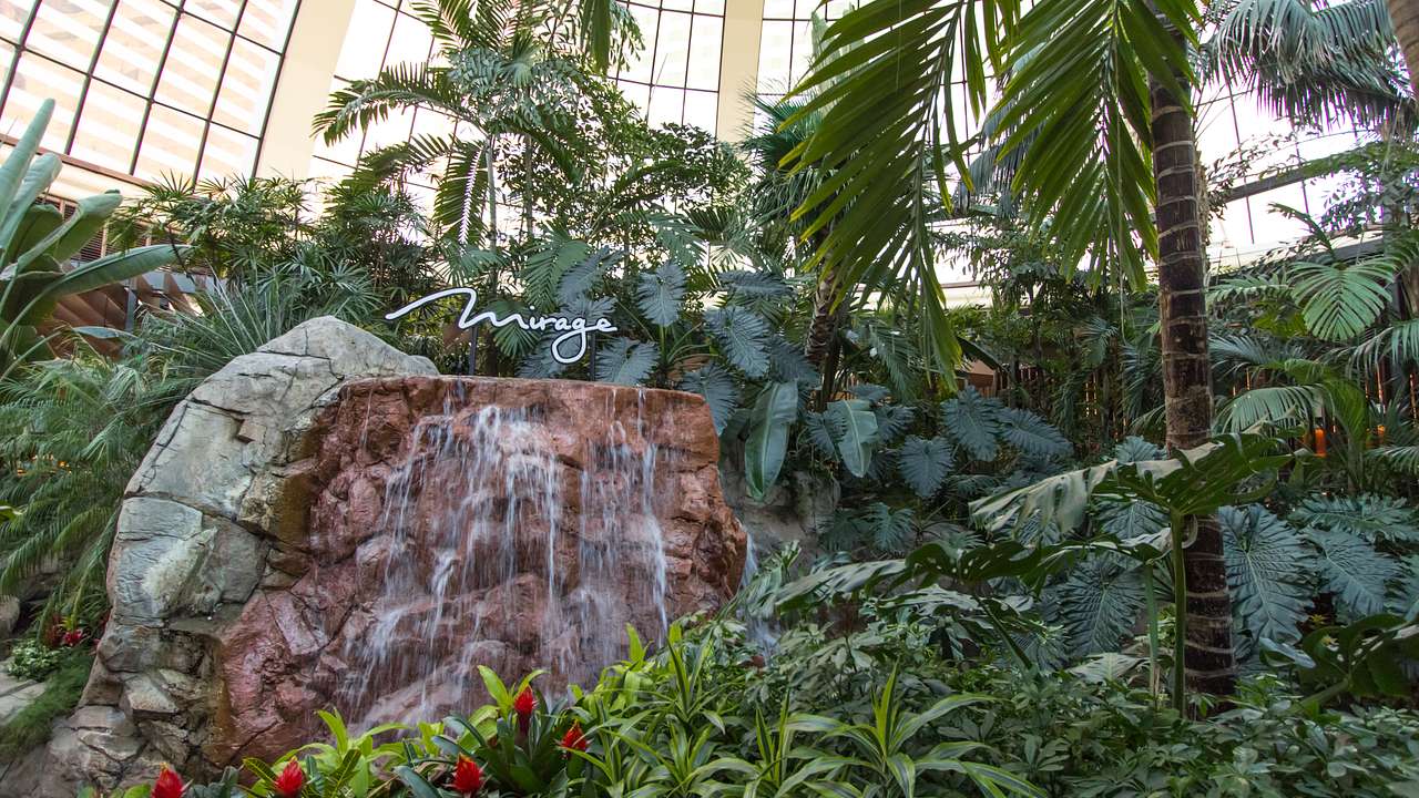 A small waterfall feature and a "Mirage" sign surrounded by greenery