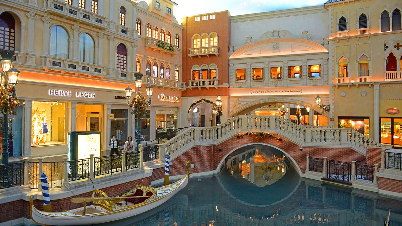 A bridge over a river with a gondola and Italian-style buildings surrounding it