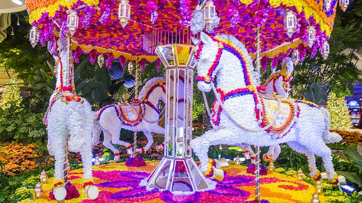 A carousel with horses made out of bright colored flowers