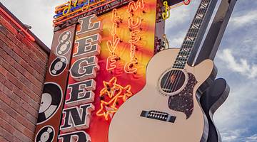 Building sign "Legends Corner" with neon lights and music notes along with a guitar