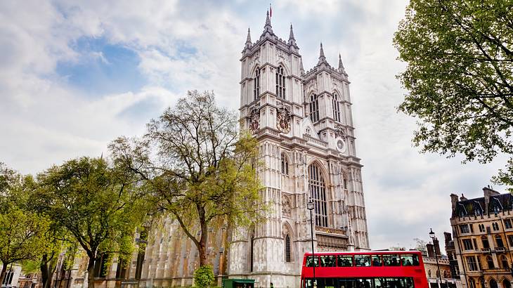 Looking up at a tall church with Gothic architecture, under a partly cloudy sky