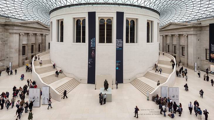 Two white staircases winding around a round white room with a modern striped roof