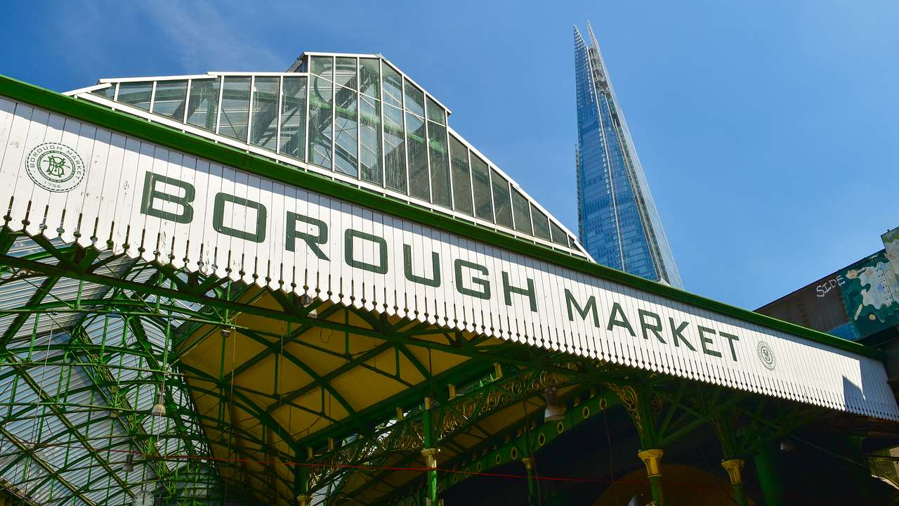 A white and green sign, "Borough Market," against a triangular building & blue sky