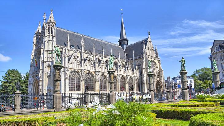 The gorgeous exterior of a cathedral with a green garden in front