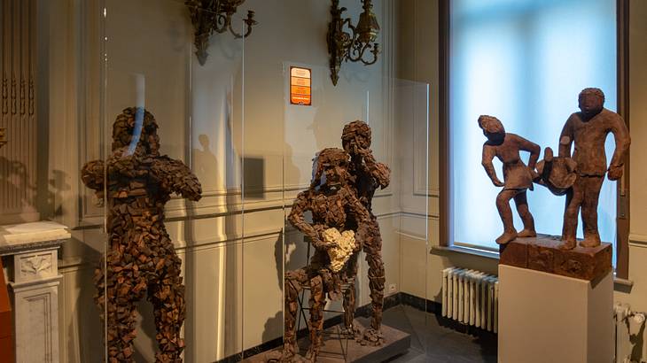 Large chocolate sculptures behind glass and small ones on a pedestal on the right