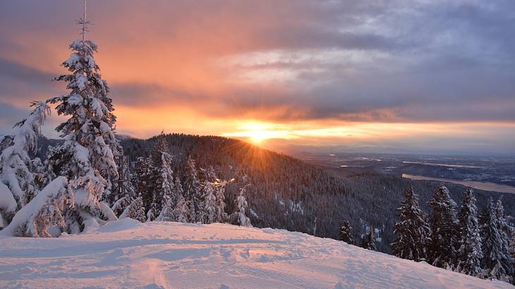 Sunrise over a mountain, looking at it from a snowy mountain top