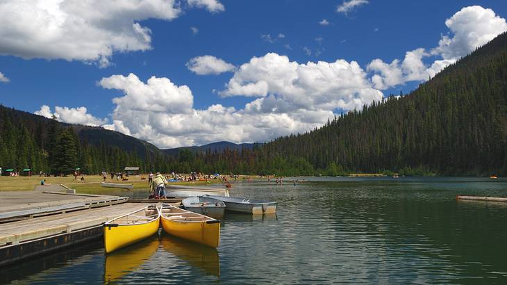 A lake with canoes tied to a dock and mountains, Manning Park, BC, Canada A lake with canoes tied to a dock and mountains, Manning Park, BC, Canada