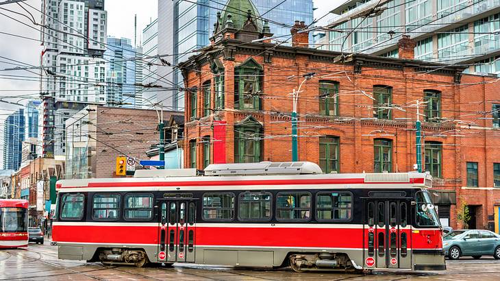 A red city tram on Queen Street West in Toronto, Ontario, Canada
