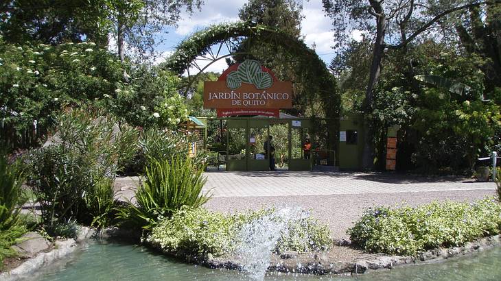 The Botanical Garden of Quito sign surrounded by greenery, Ecuador