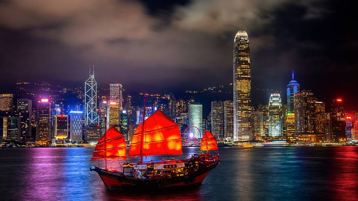 A harbour with a ship and buildings in background at night, Hong Kong A harbour with a ship and buildings in background at night, Hong Kong